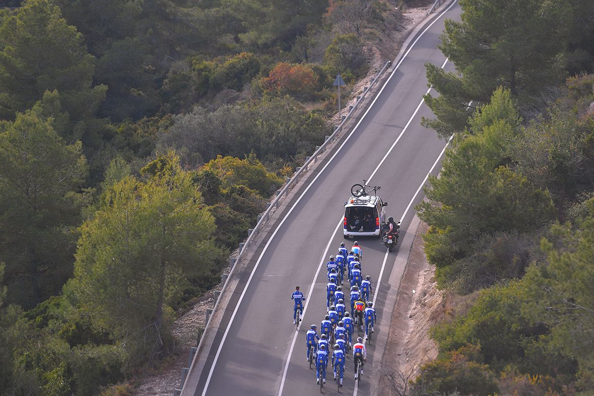 A car drives in front of the riders