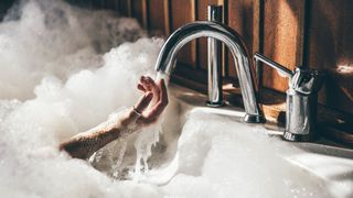 A bubble bath with a hand reaching out of it