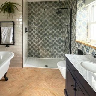 bathroom with shower enclosure tiled in green flower pattern tile