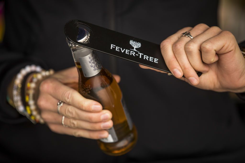 An employee opens a bottle of tonic water at the Fevertree Drinks Plc Gin and Tonic bar during the annual Cowes Week sailing regatta near Cowes on the Isle of Wight, U.K. on Tuesday, Aug. 13, 2019. A cool start to summer contributed to U.K. sales rising just 5% in the opening six months of the year, an outcome that disappointed most analysts, particularly in light of the stellar growth rates of recent years. Photographer: Jason Alden/Bloomberg