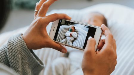 Mother snapping a photo of her newborn