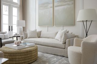White sofa in a white living room with pale abstract wall art
