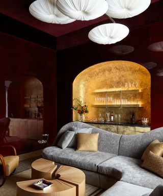Home bar in a living room alcove decorated with gold metallics