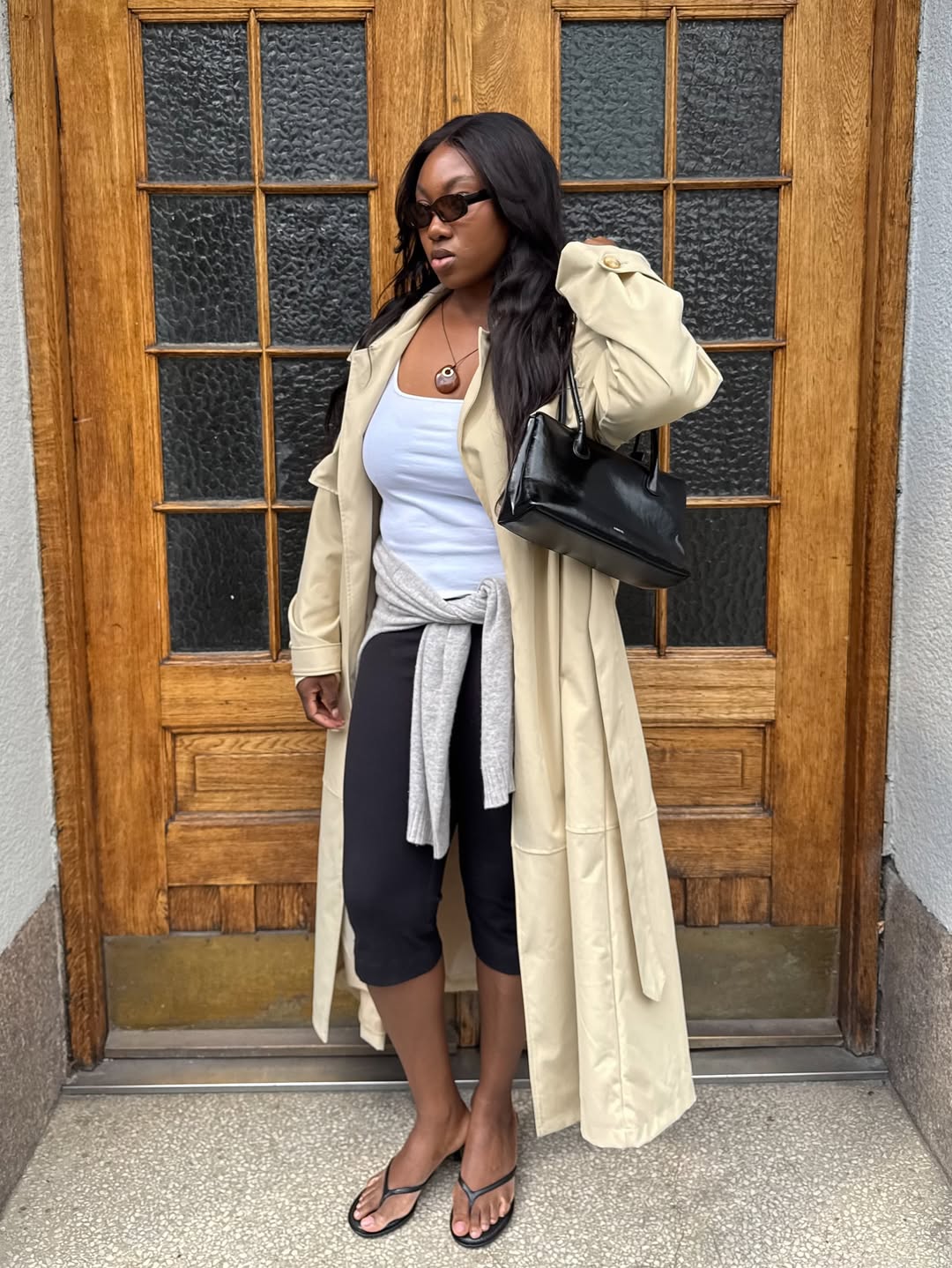 @nnennaechem wears a trench, grey tank top, black capri pants and flip-flop kitten heels