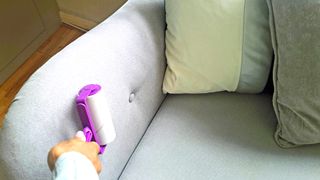 A lint roller being used to clean furniture