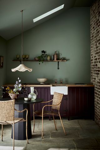 Green walls and aubergine purple kitchen cabinets