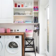 White utility room with washing machine and tumble dryer and open shelving