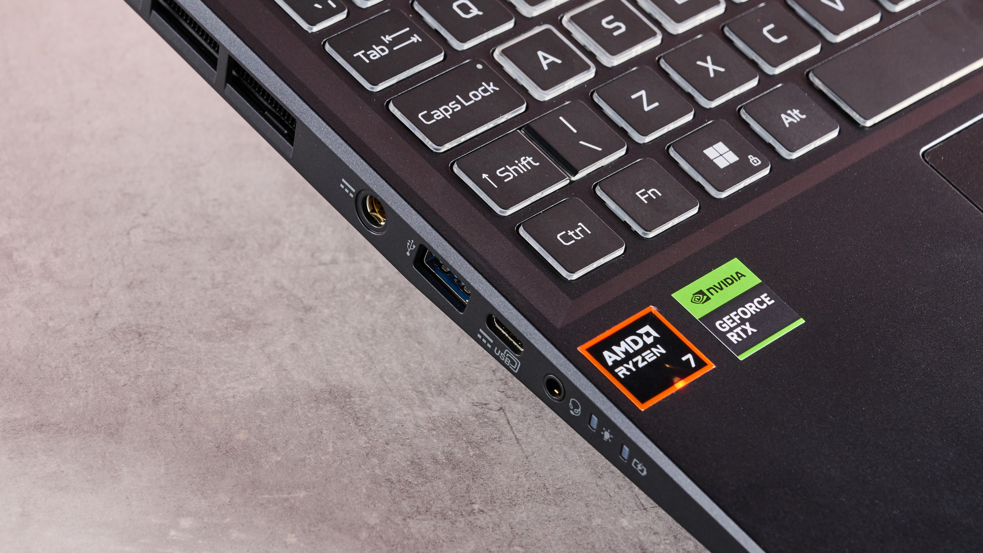 The Acer Nitro 14 compact gaming laptop photographed on a coral background.