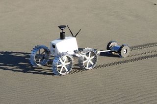 Engineering models of the dual rover system including the four-wheeled Moonraker and the two-wheeled Tetris rovers undergoing field testing at the Nakatajima Dune, Hamamatsu, Shizuokain, Japan, in late 2013.