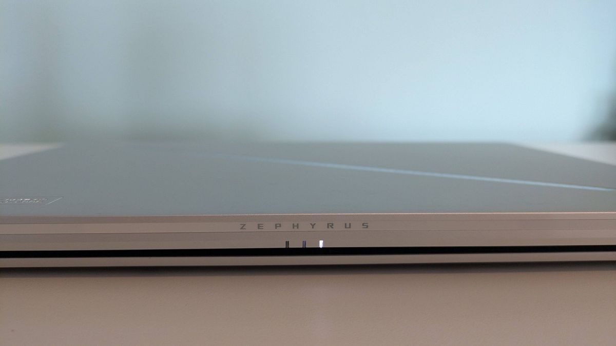 Close-up of Zephyrus logo on rear of Asus ROG Zephyrus G14 (2025), closed on desk with green background