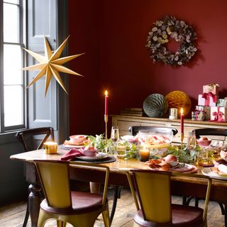Christmas dining room table with decorations and golden star hanging at the window