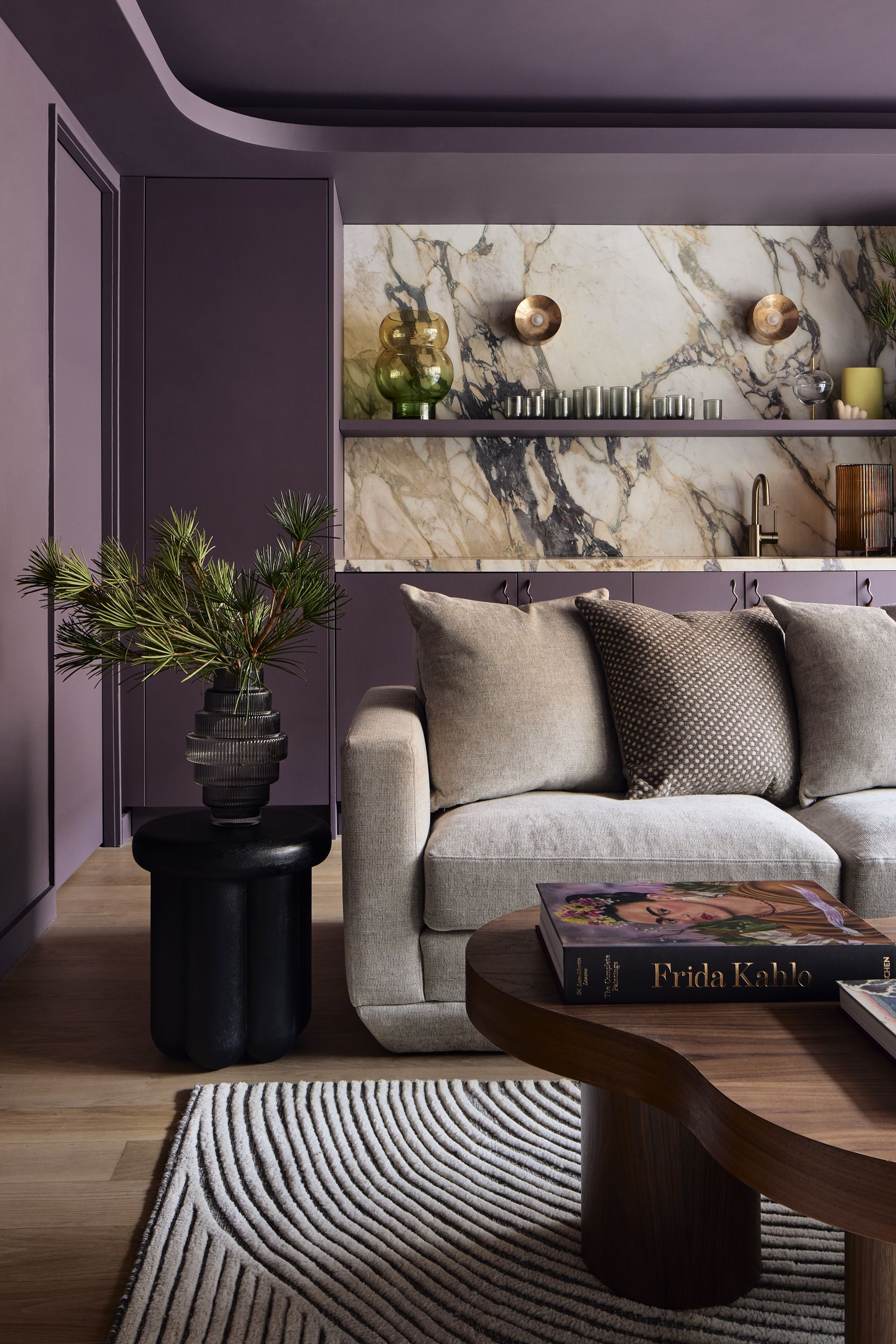 a purple home cinema room with a home bar and large grey sofa 