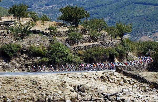 The main bunch ascends a rocky climb