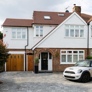 sloping roof house with white windows and car