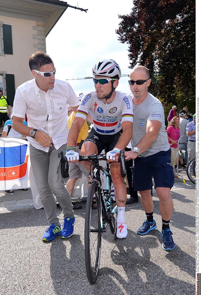 Mark Cavendish is helped back onto his bike after a crash