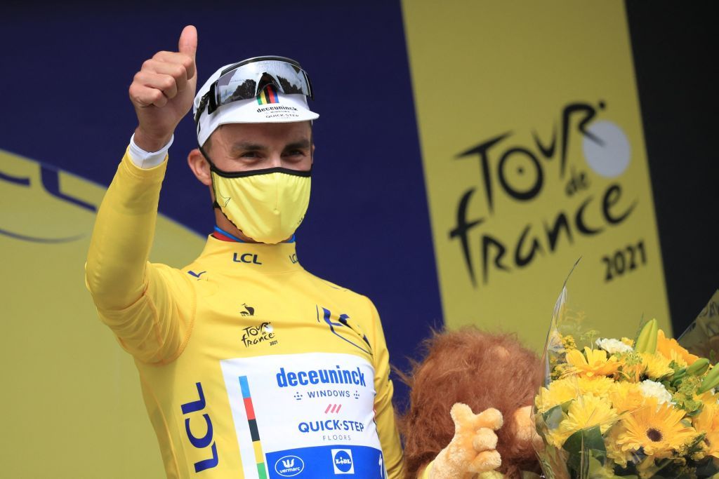 TOPSHOT Team Deceuninck Quicksteps Julian Alaphilippe of France celebrates his overall leaders yellow jersey on the podium at the end of the 1st stage of the 108th edition of the Tour de France cycling race 197 km between Brest and Landerneau on June 26 2021 Photo by christophe petit tesson POOL AFP Photo by CHRISTOPHE PETIT TESSONPOOLAFP via Getty Images