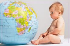A baby looking at a globe