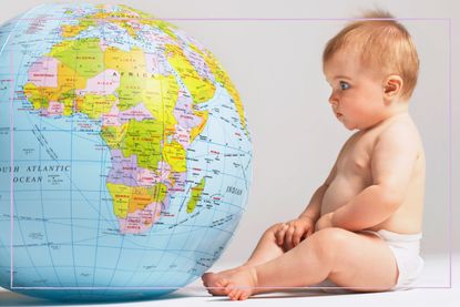 A baby looking at a globe