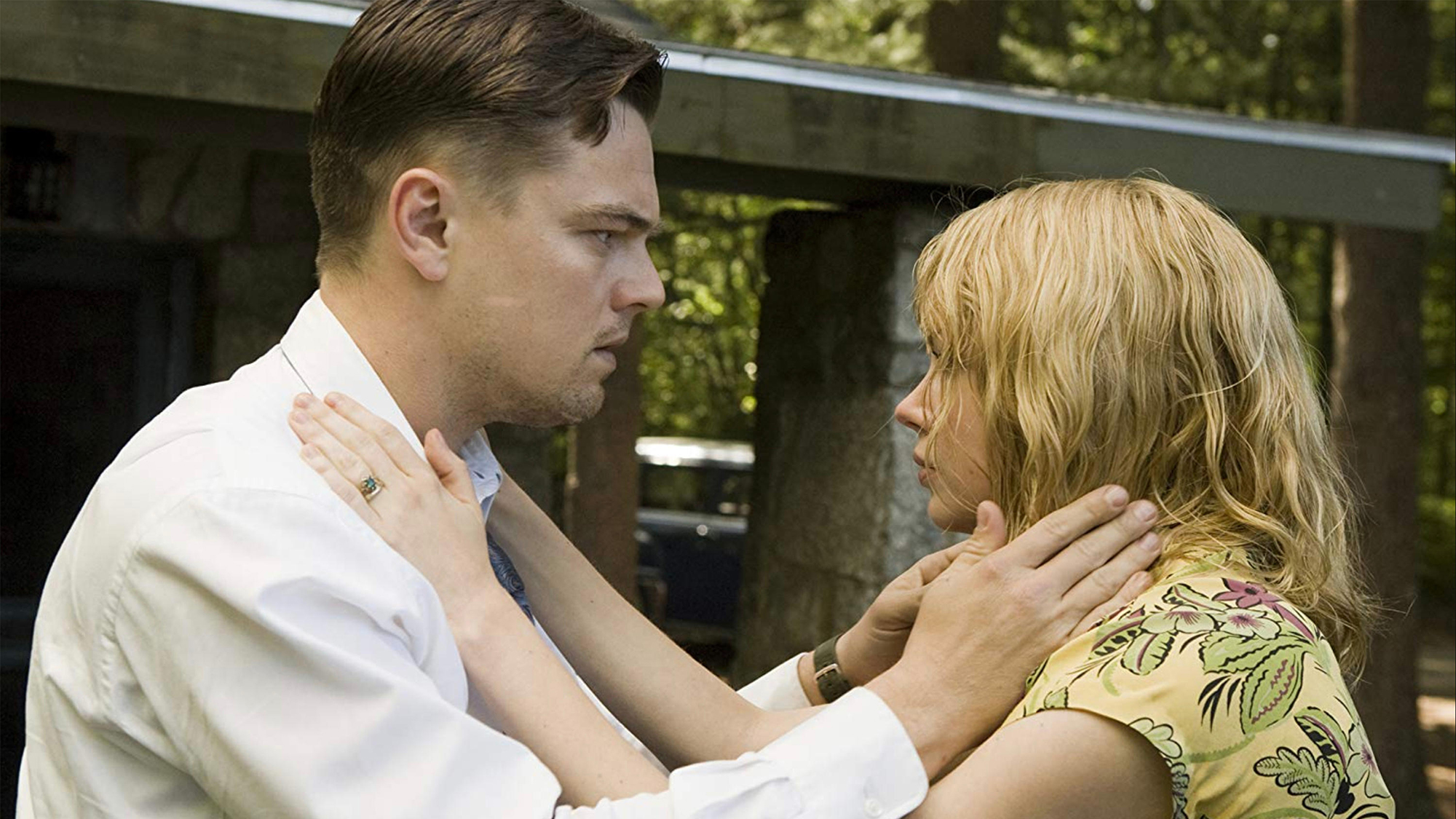 (L, R) Leonardo DiCaprio (as Teddy) and Michelle Williams (as Dolores) standing at Shutter Island