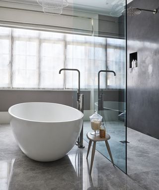 Wet room ideas in a gray scheme with white bath tub.