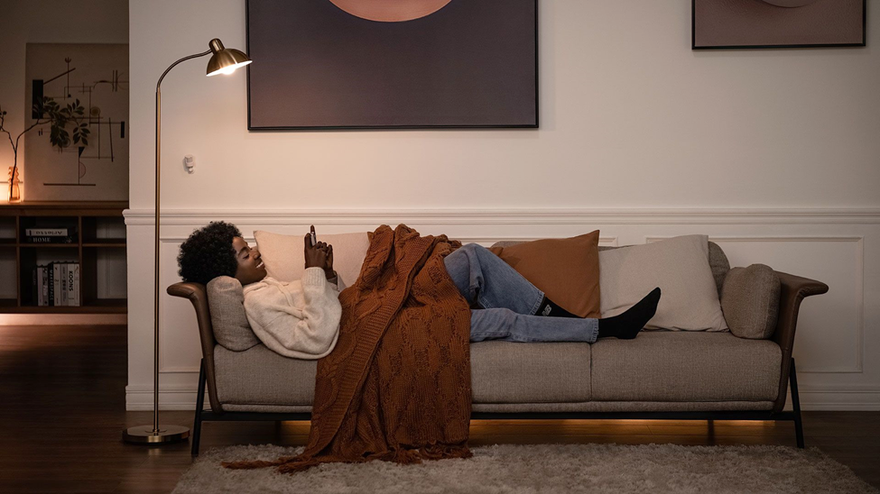 Woman laying down on the couch playing with her phone