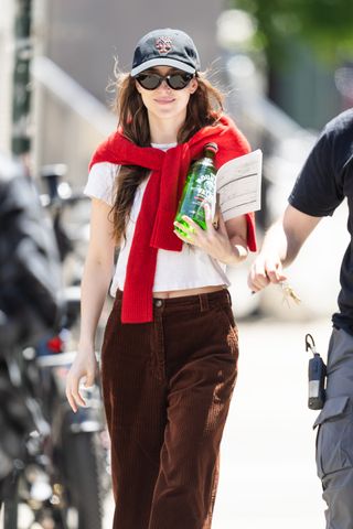 Red jumper trend: Dakota Johnson wears a red jumper over her shoulders