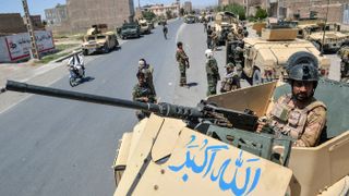 An Afghan National Army commando stands guard on top of a vehicle along a road in Herat province on 1 August 2021