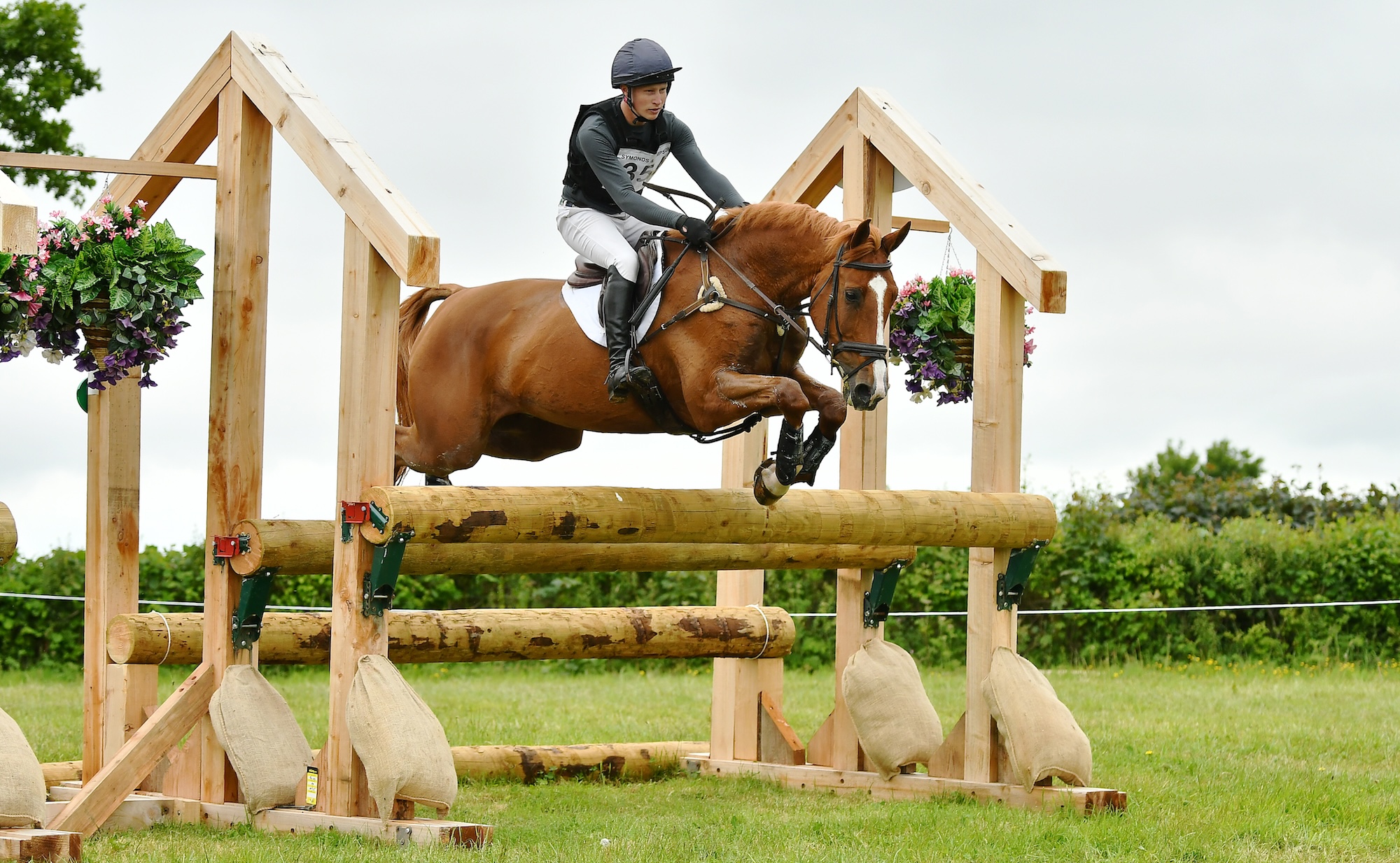 Rider Ollie Thompson jumping a cross-country fence with a chestnut horse