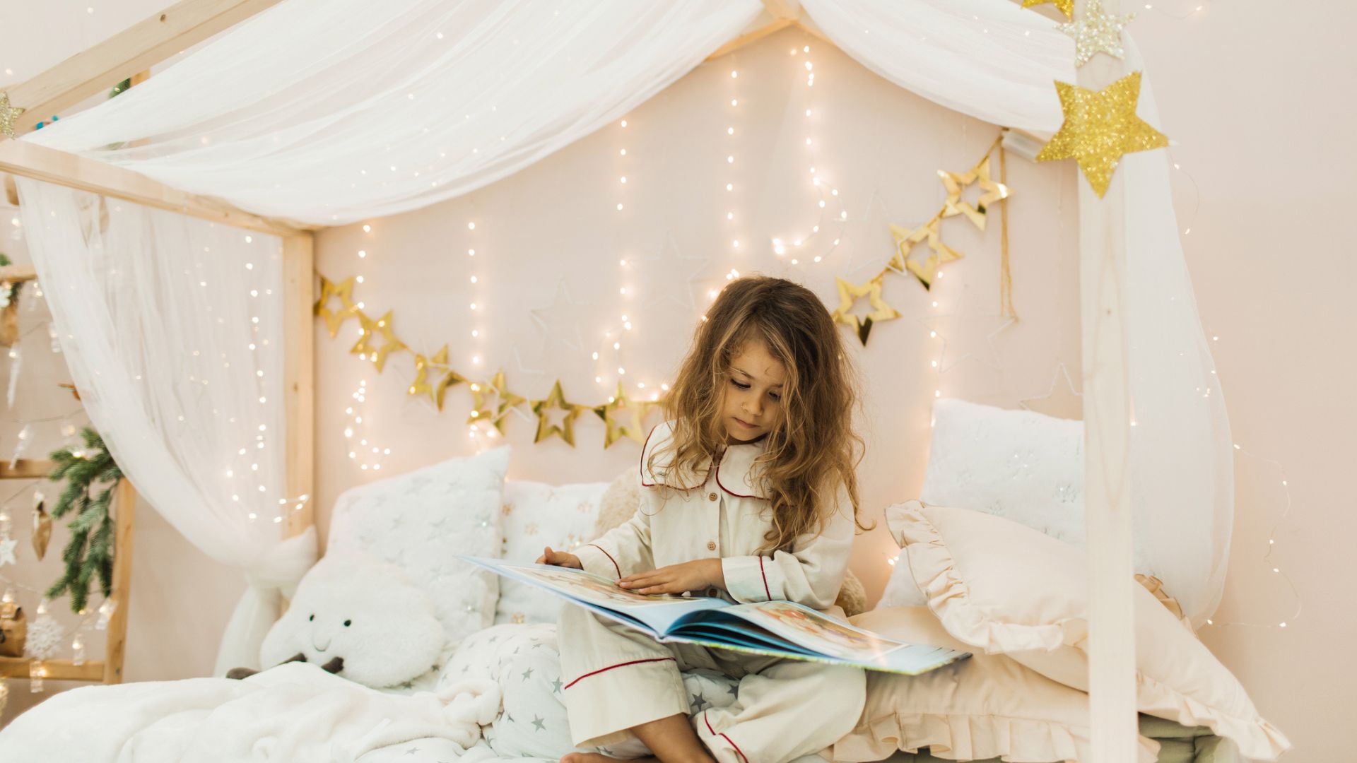 Child reading before bed in a bedroom decorated with gold stars