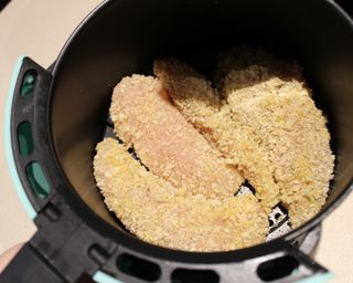 Uncooked chicken tender strips in the Dash 2-quart air fryer