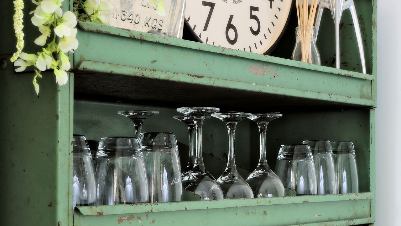 glasses and plates arranged in green shelving unit