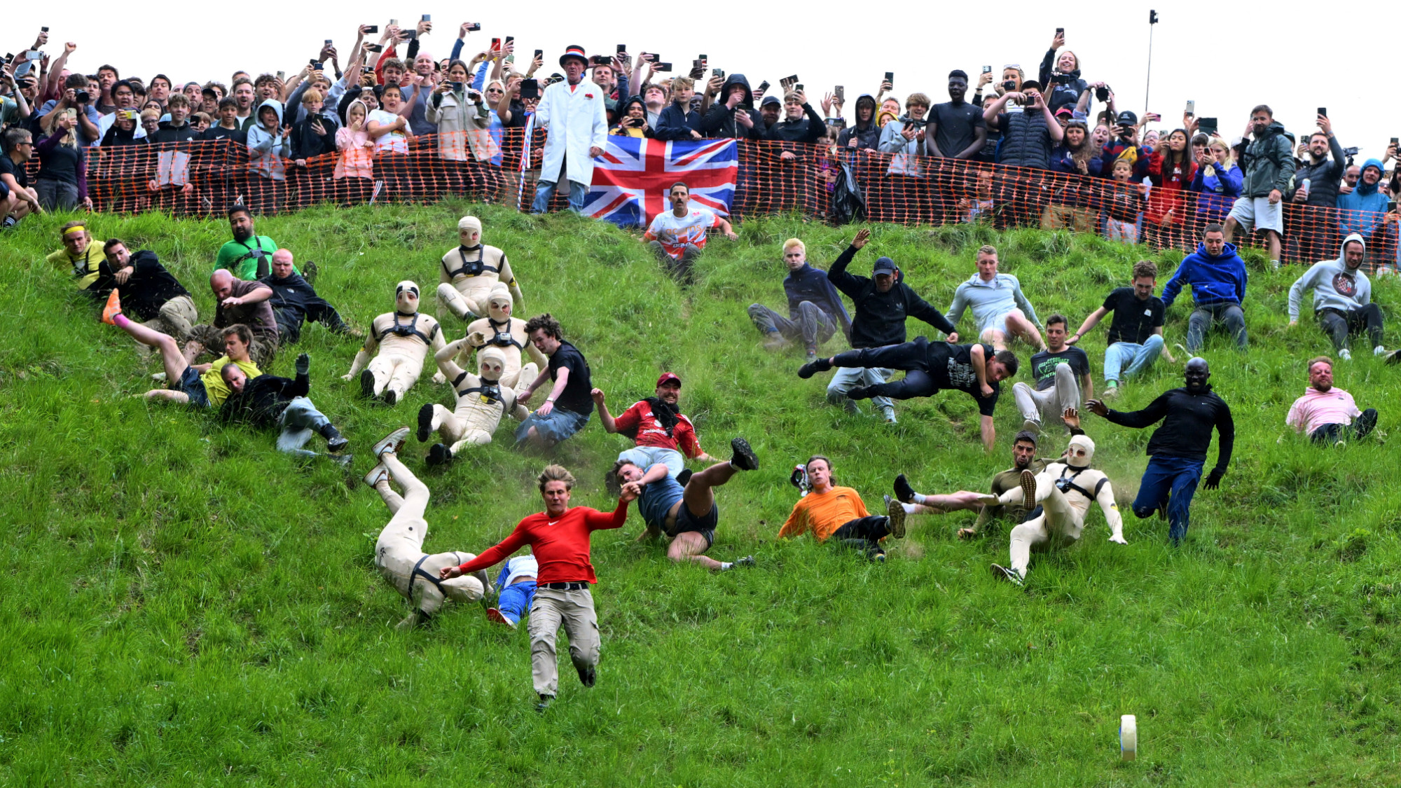 Participants tumble down a hill during the Cheese Rolling contest in England