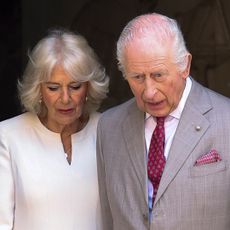 King Charles and Queen Camilla looking downcast