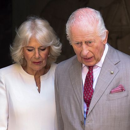 King Charles and Queen Camilla looking downcast