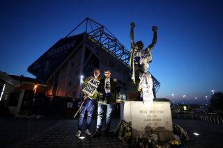 Leeds fans make their feelings clear, next to the statue of club great Billy Bremner