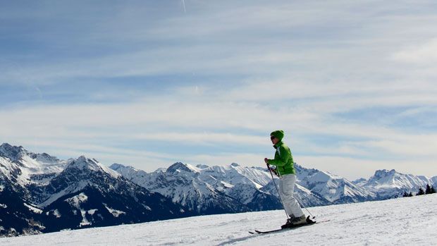 Skiier slides in front of the Alp mountains