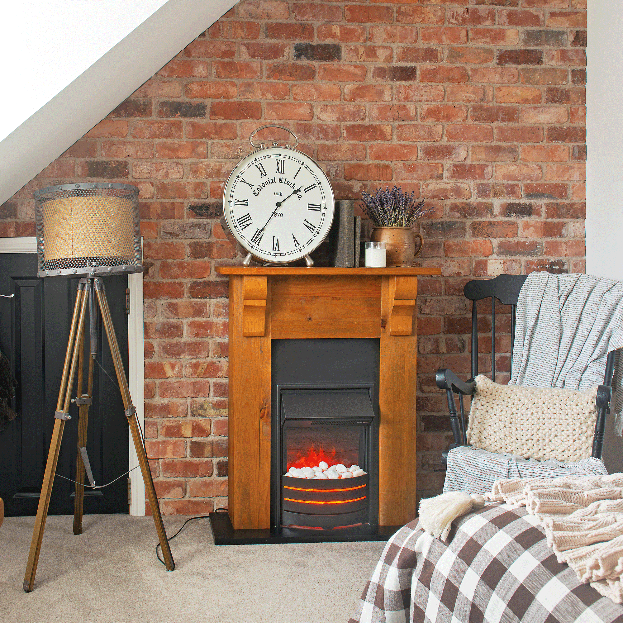 a neutral bedroom with an exposed brick wall and a fireplace with an electric fire and a clock