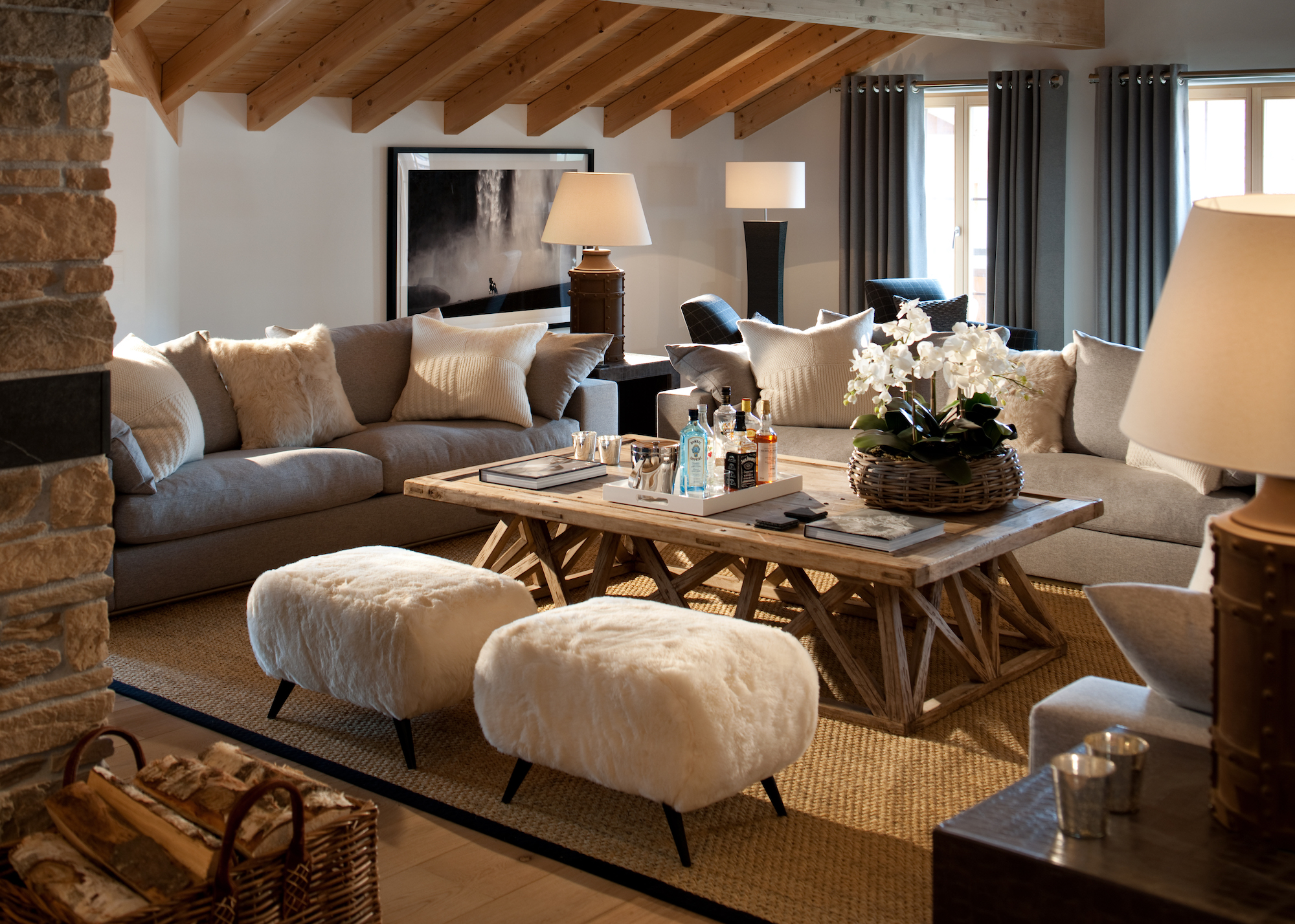 living room with L-shape sofa and coffee table and sheepskin stools