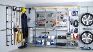 Garage storage wall with shelf and brackets, full of tools, wells and work equipment
