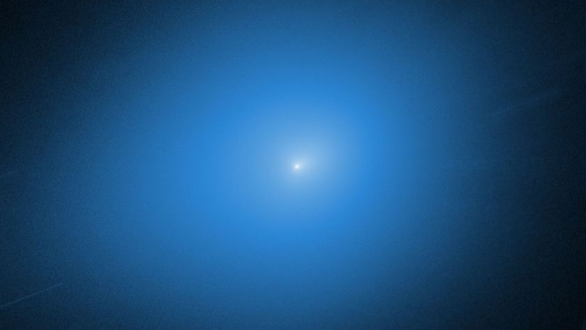 A white light of the comet 3I/ATLAS is surrounded by a blue glow against a black background