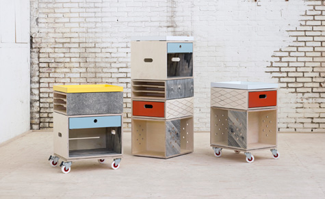 A selection of three wooden storage boxes. Left and Right, the boxes are on wheels. Centre. A tower of wooden boxes are standing on top of each other. 