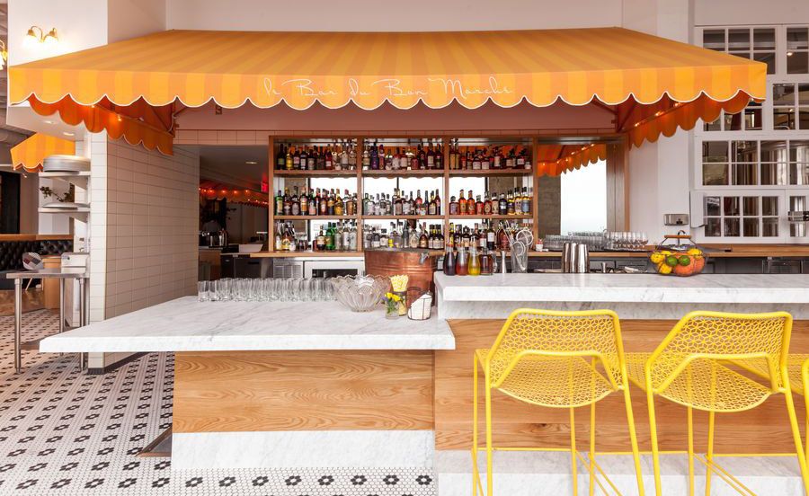 The bar counter with yellow coloured and two chairs