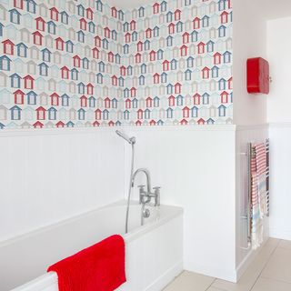 bathroom with bathtub beach hut designed wallpaper and white tiles wall