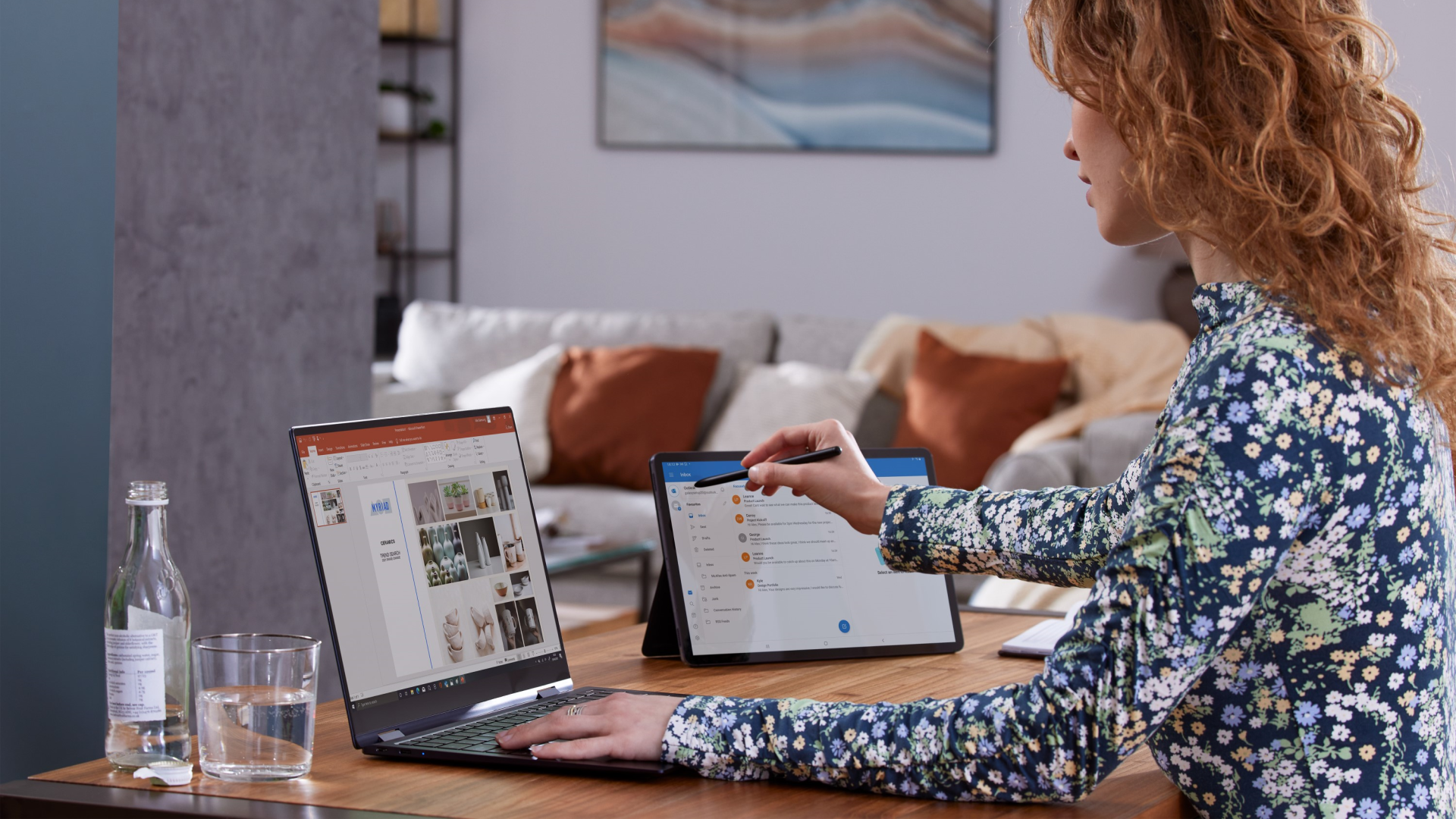 Woman sitting at desk using a laptop and tablet to work