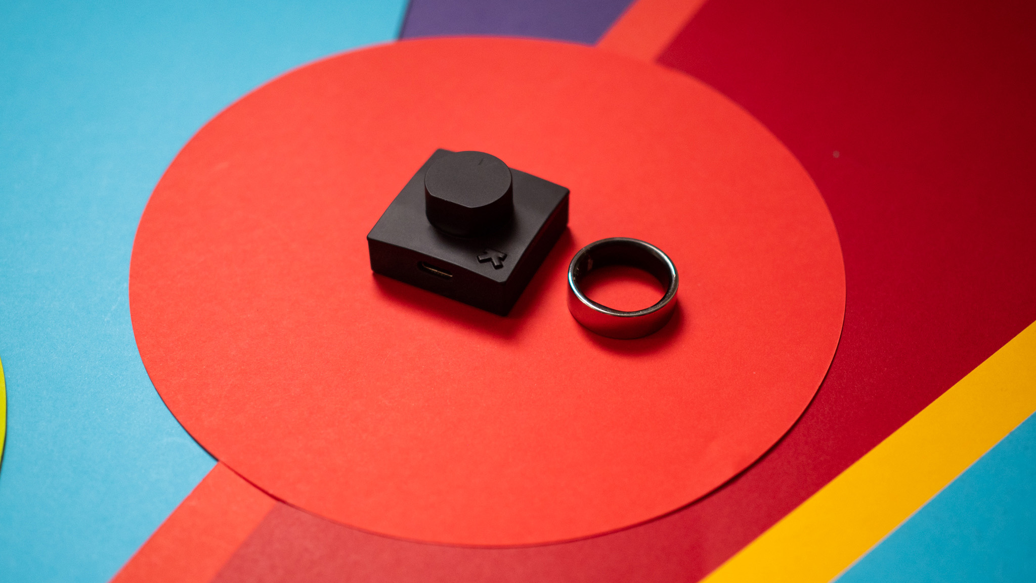 Ultrahuman Ring Air smart ring next to its charging station