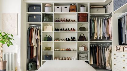 A large open closet built in, spanning one wall. White shelving with shoes and hanging clothes 