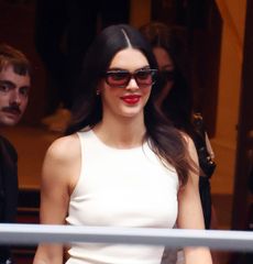 Kendall Jenner wearing black shorts, a red tank top, and a Bottega Veneta Duffle Bag