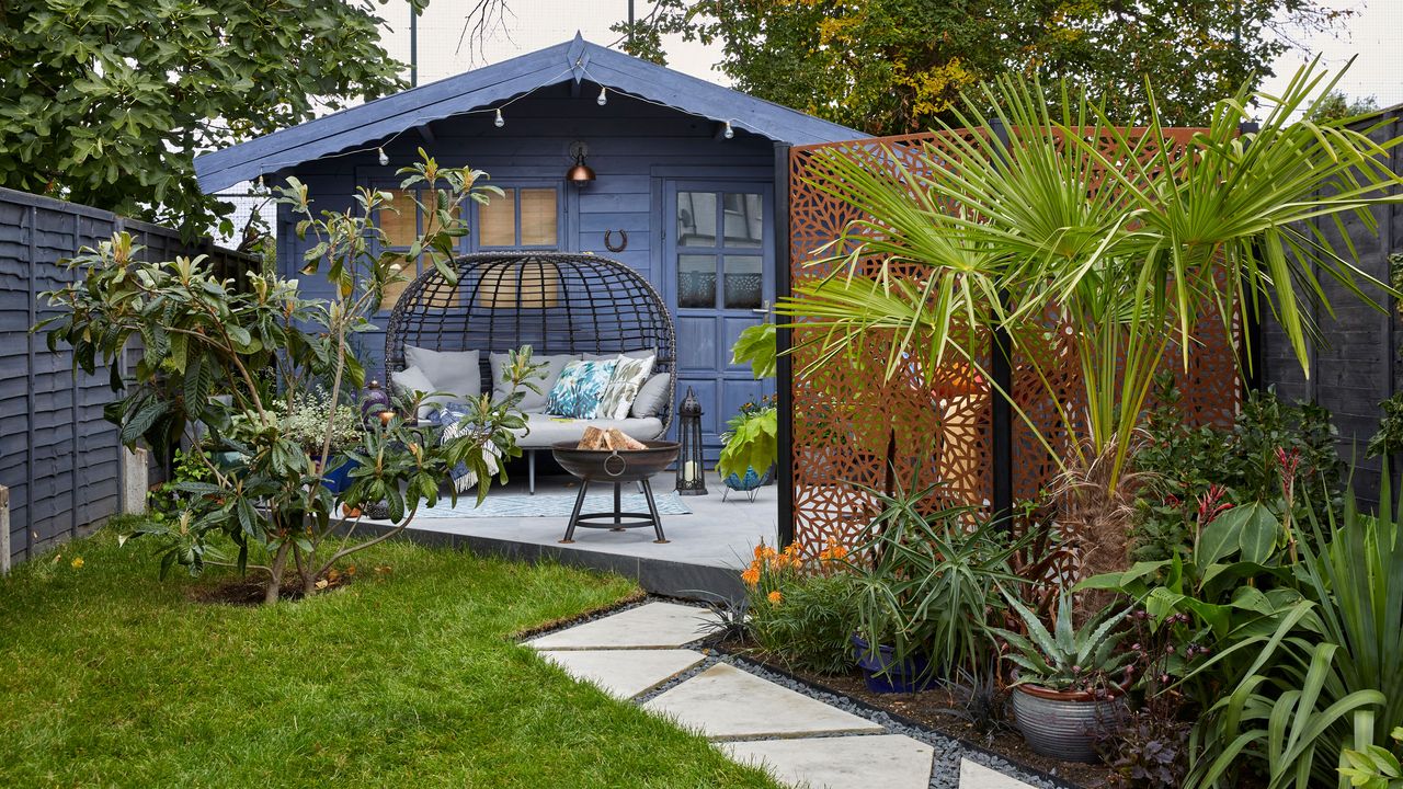 Angled pathway leading through lawn and flowerbeds to a summerhouse