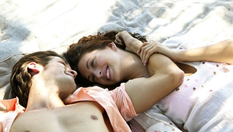  couple laying together on beach - stock photo