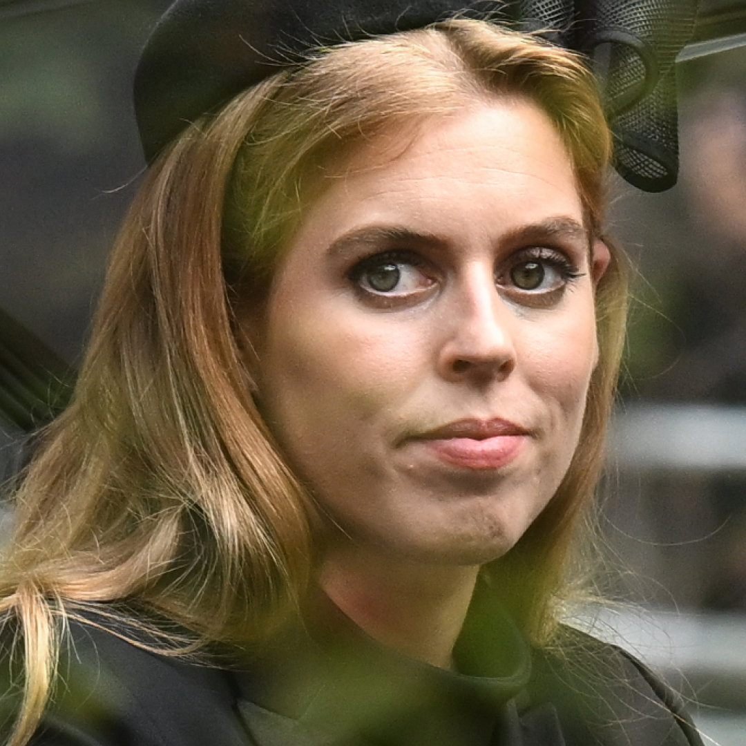Princess Beatrice wears a black bow in her hair and a green coat